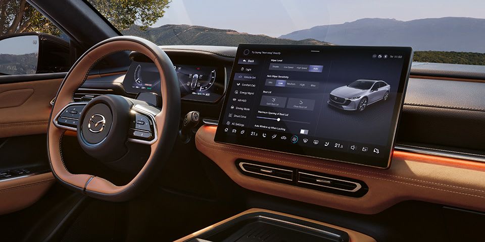 Interior view of the all-electric Mazda 6e hatchback with large centre touchscreen and quality black and tan materials