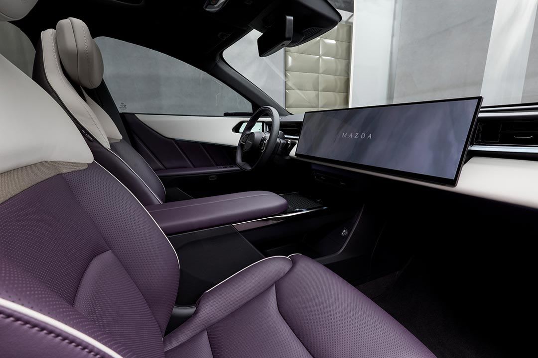 Side view of the large central touchscreen and purple leather seat trim of the all-electric Mazda CX-63 SUV