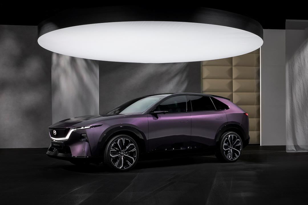 Front three quarter view of a Nightfall Violet all-electric Mazda CX-6e SUV on display
