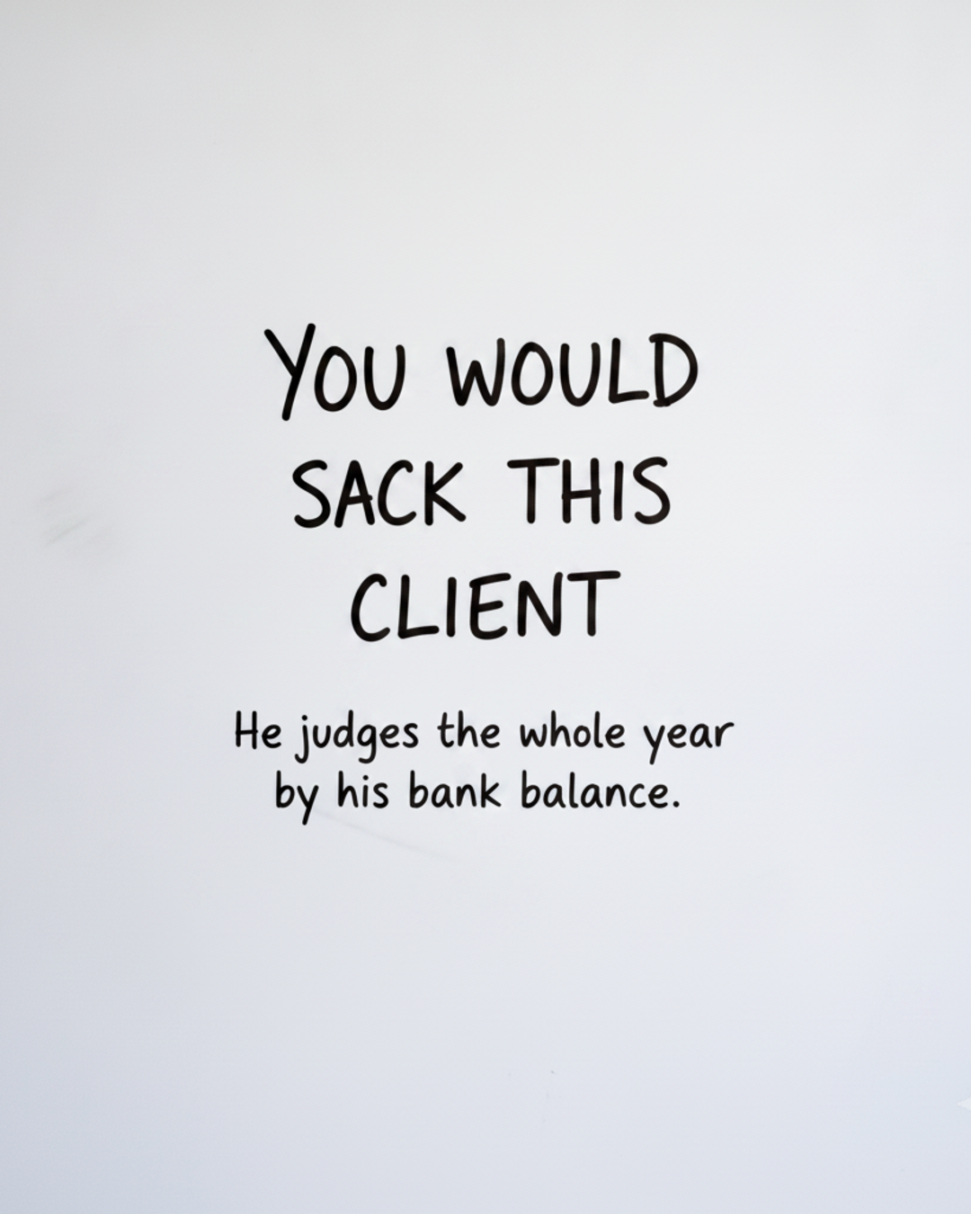 Whiteboard with the words You would sack this client written in black marker, above the line He judges the whole year by his bank balance