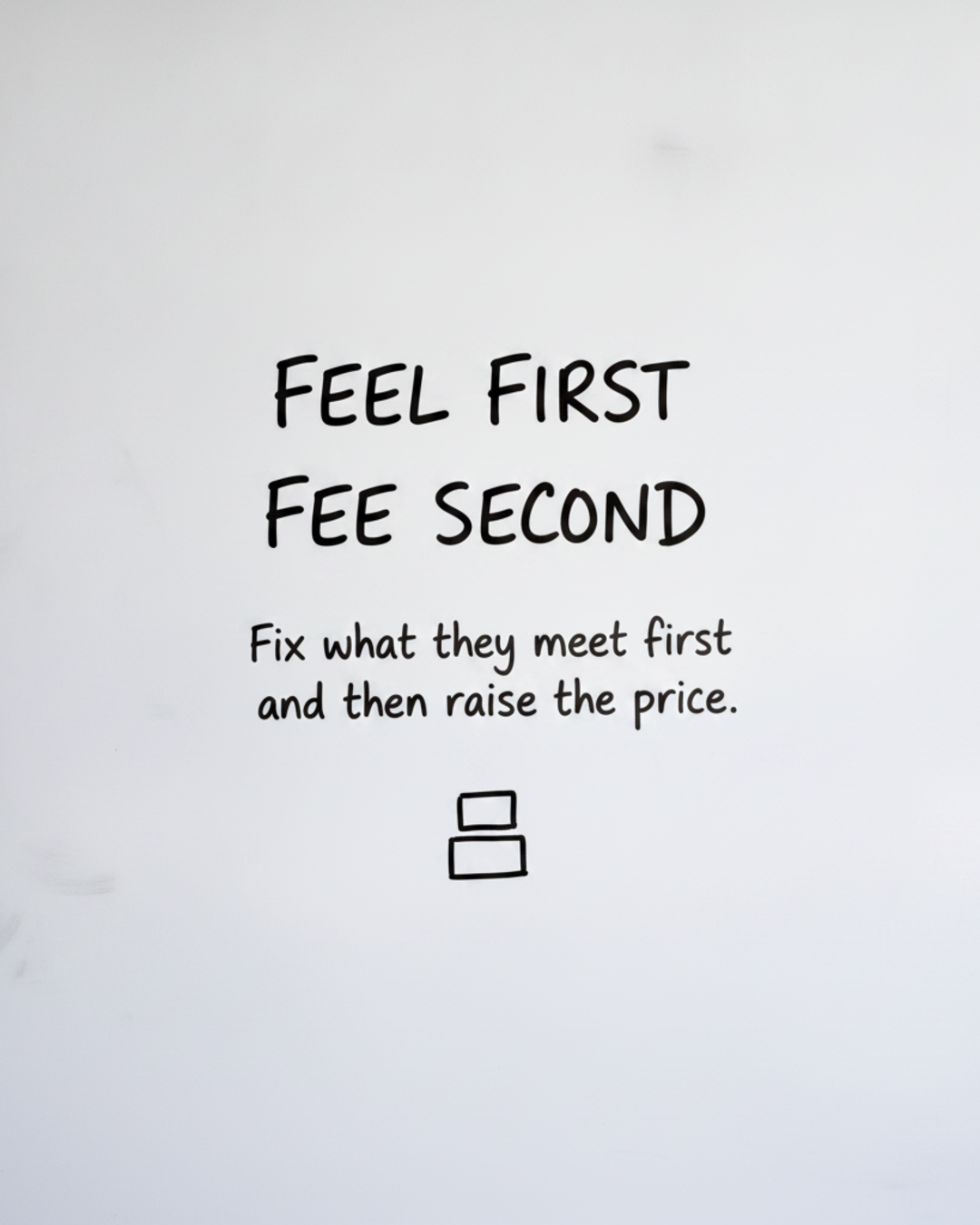 Whiteboard with the words FEEL FIRST FEE SECOND written in black marker above two stacked boxes
