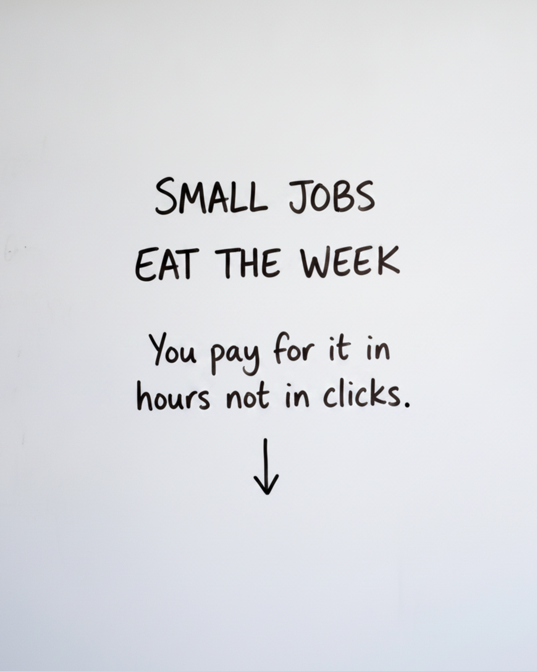 Whiteboard with the words Small jobs eat the week written in black marker above a short downward arrow