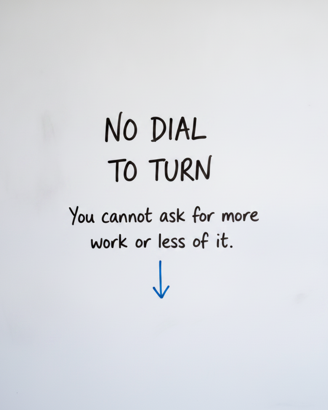 Whiteboard with the words No dial to turn written in black marker above a blue downward arrow