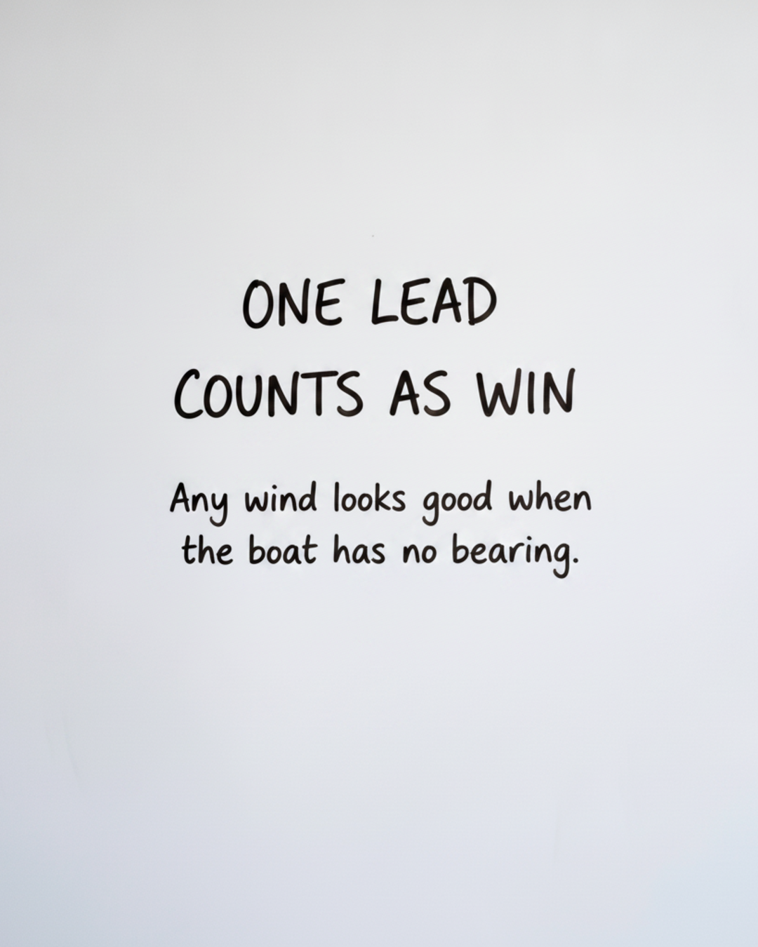 Whiteboard with the words One lead counts as win written in black marker