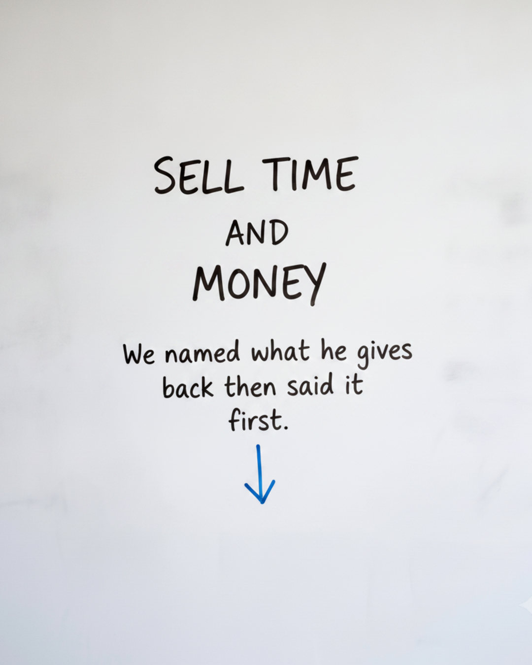 Whiteboard with the words Sell time and money written in black marker above a blue downward arrow