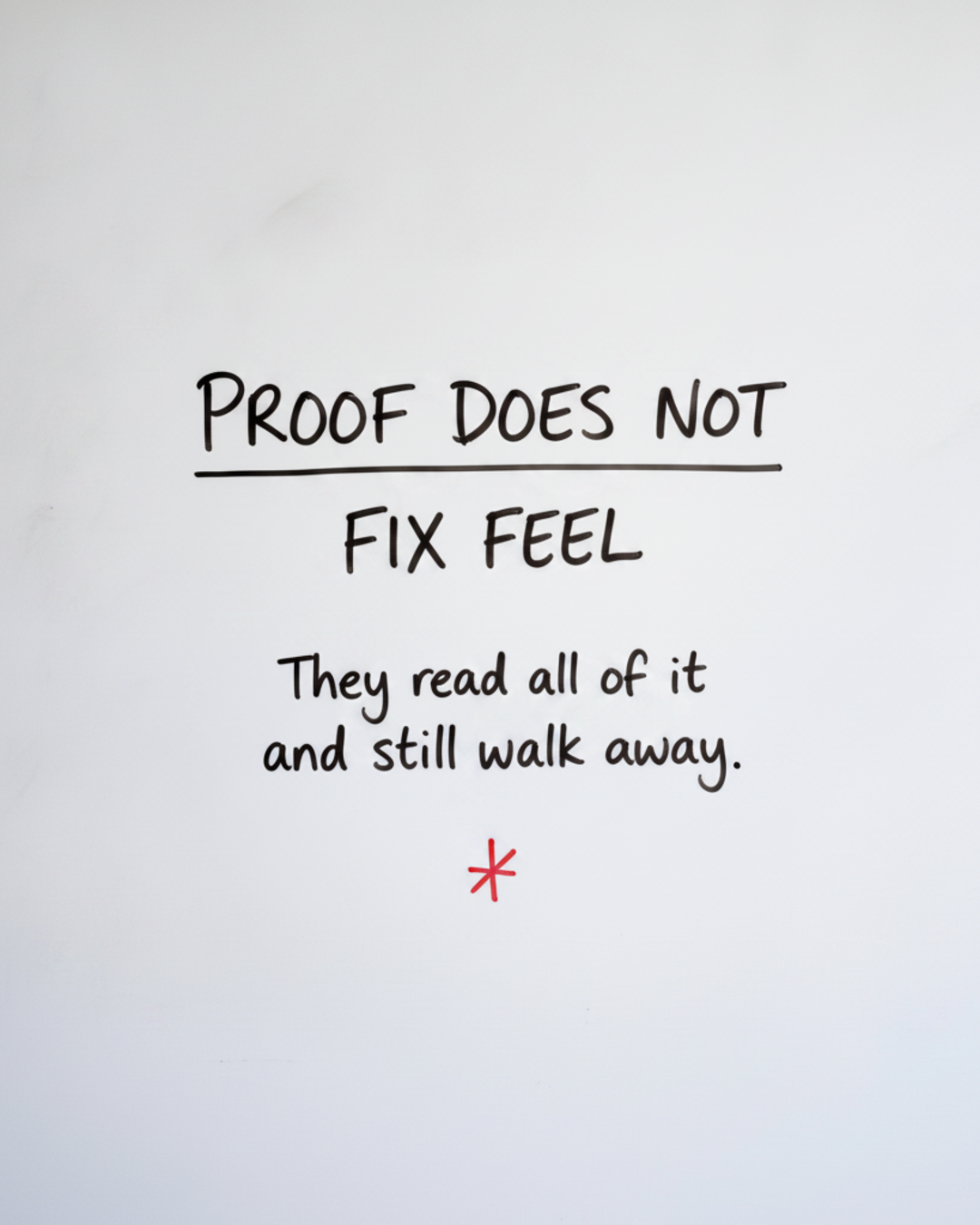 Whiteboard with the words PROOF DOES NOT FIX FEEL written in black marker above a red cross mark