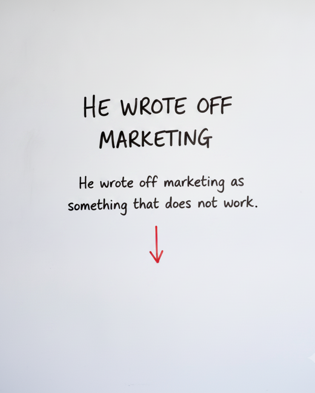 Whiteboard with the words HE WROTE OFF MARKETING in black marker above a red downward arrow