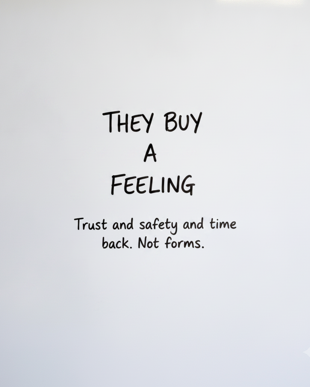 Whiteboard with the words They buy a feeling written in black marker, with the word feeling circled in red