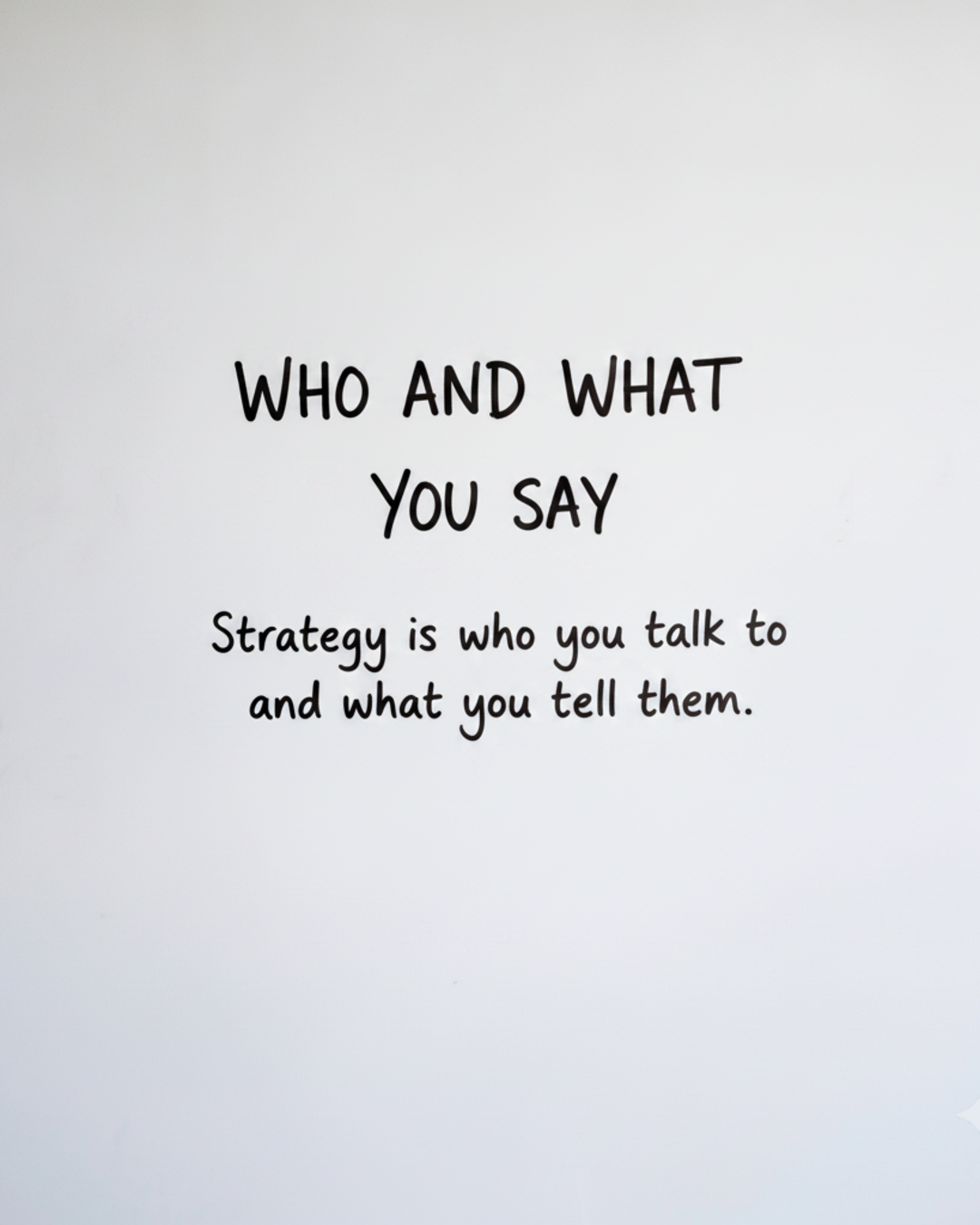 Whiteboard with the words WHO AND WHAT YOU SAY in black marker, with the word WHO circled in red