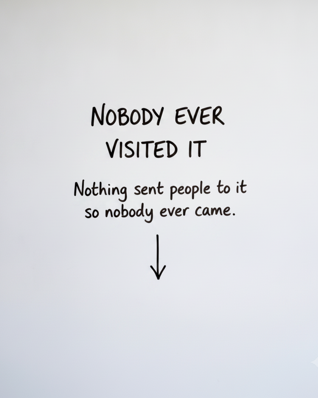 Whiteboard with the words NOBODY EVER VISITED IT in black marker above a short downward arrow