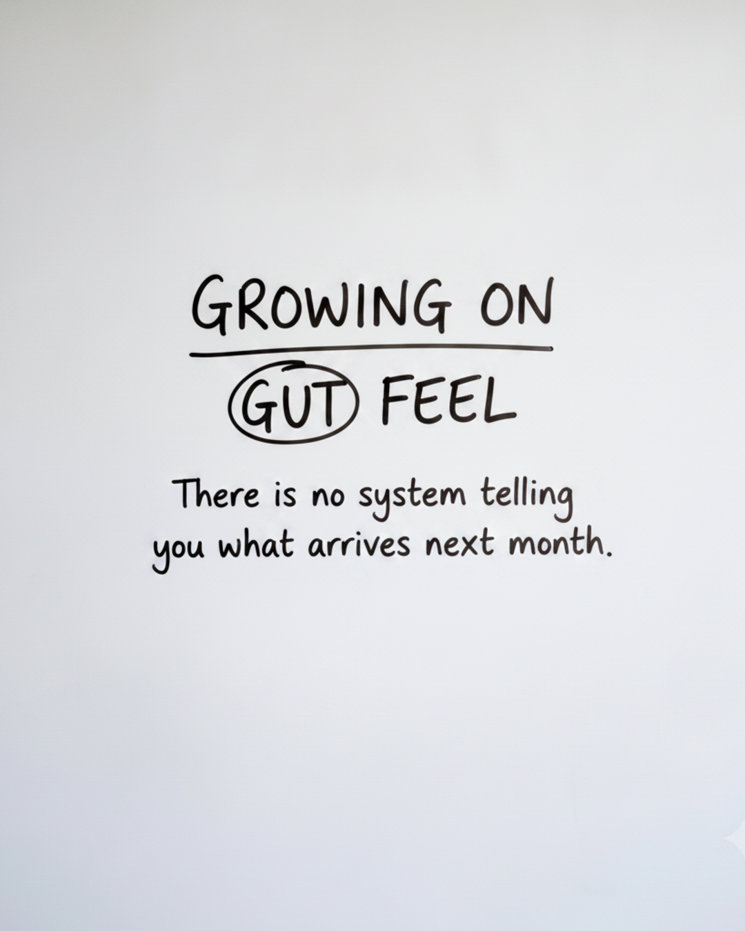 Whiteboard with the words Growing on gut feel written in black marker, with the word gut circled