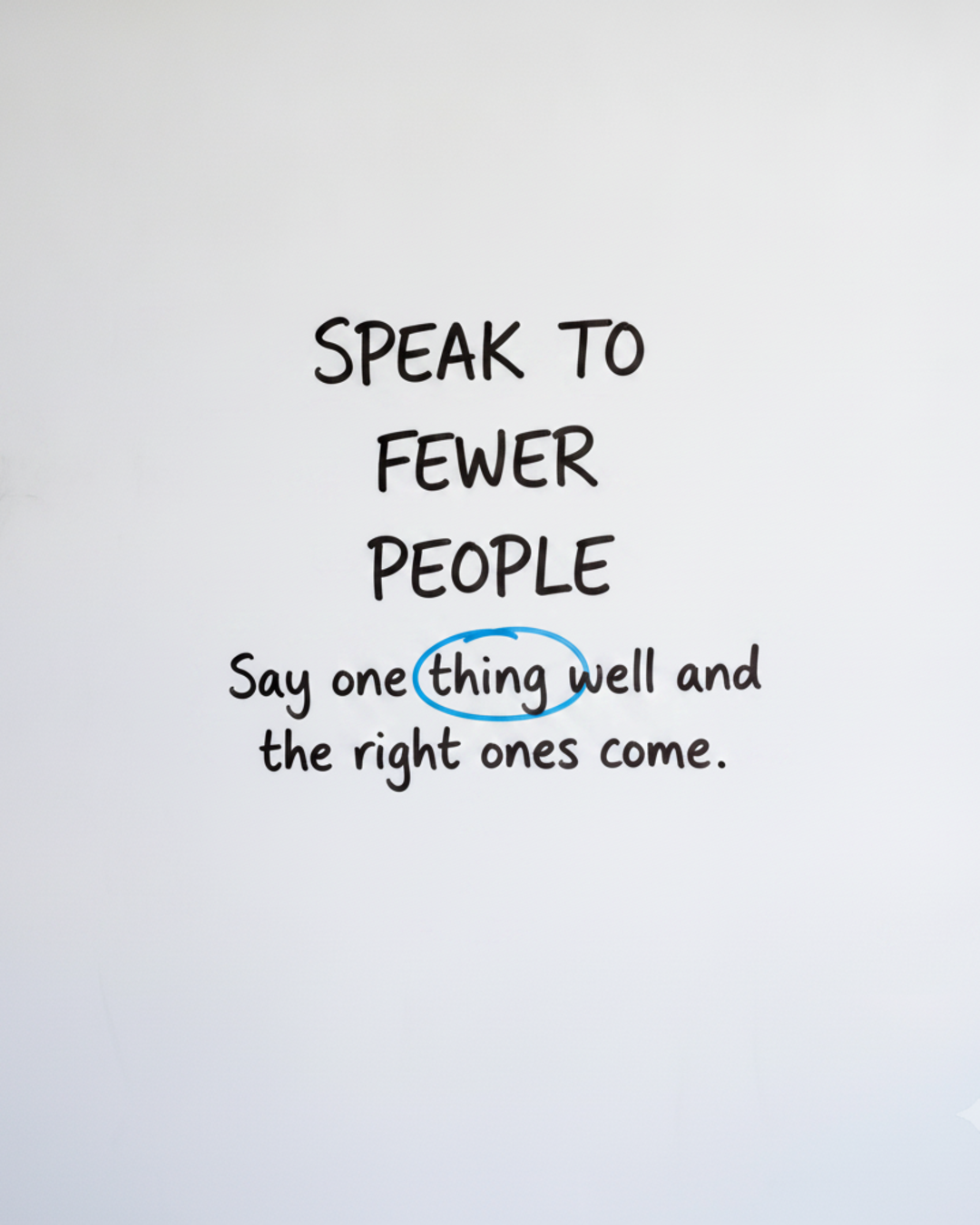 Whiteboard with the words Speak to fewer people in black marker and the word Fewer circled in blue