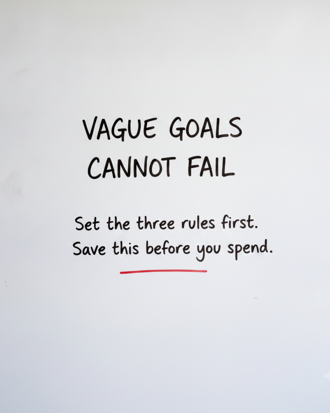 Whiteboard with the words Vague goals cannot fail written in black marker with a red underline beneath the last line