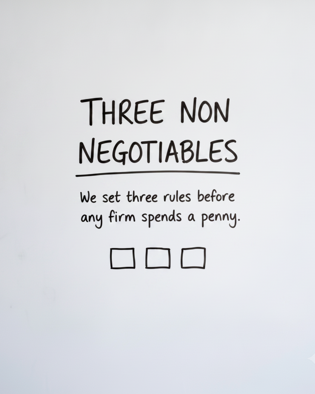 Whiteboard with the words Three non negotiables written in black marker above three empty boxes
