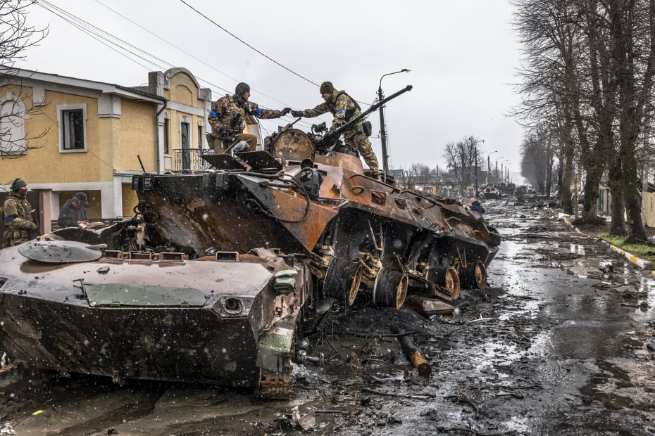 Ukrainske soldater leder efter brugbare dele fra resterne af et russisk militærkøretøj i Butja nær hovedstaden Kyiv. Herfra er der de seneste dage kommet billeder ud der viser likvideringer af talrige civile ukrainere.