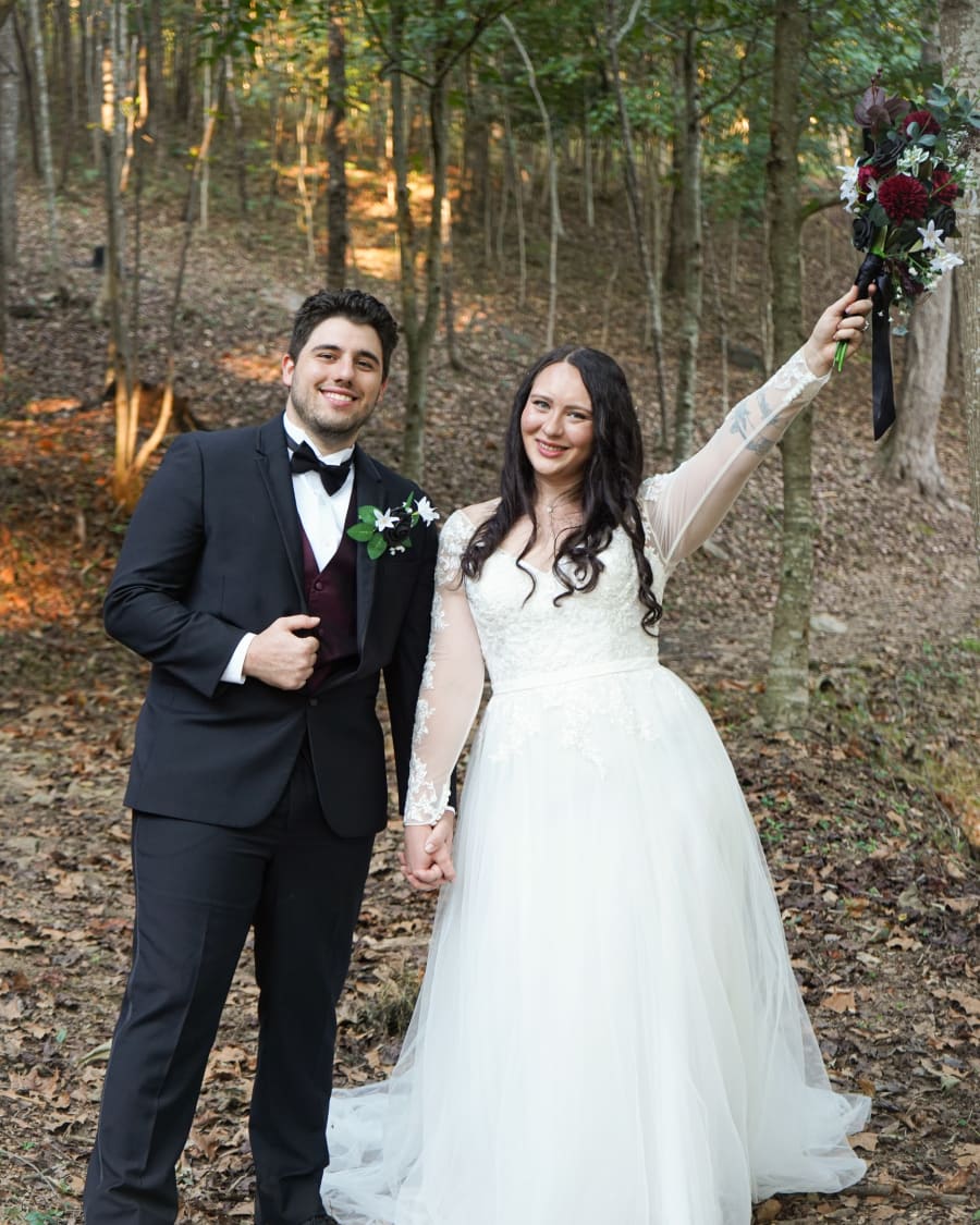 Nick and Makenzie holding hands in the woods