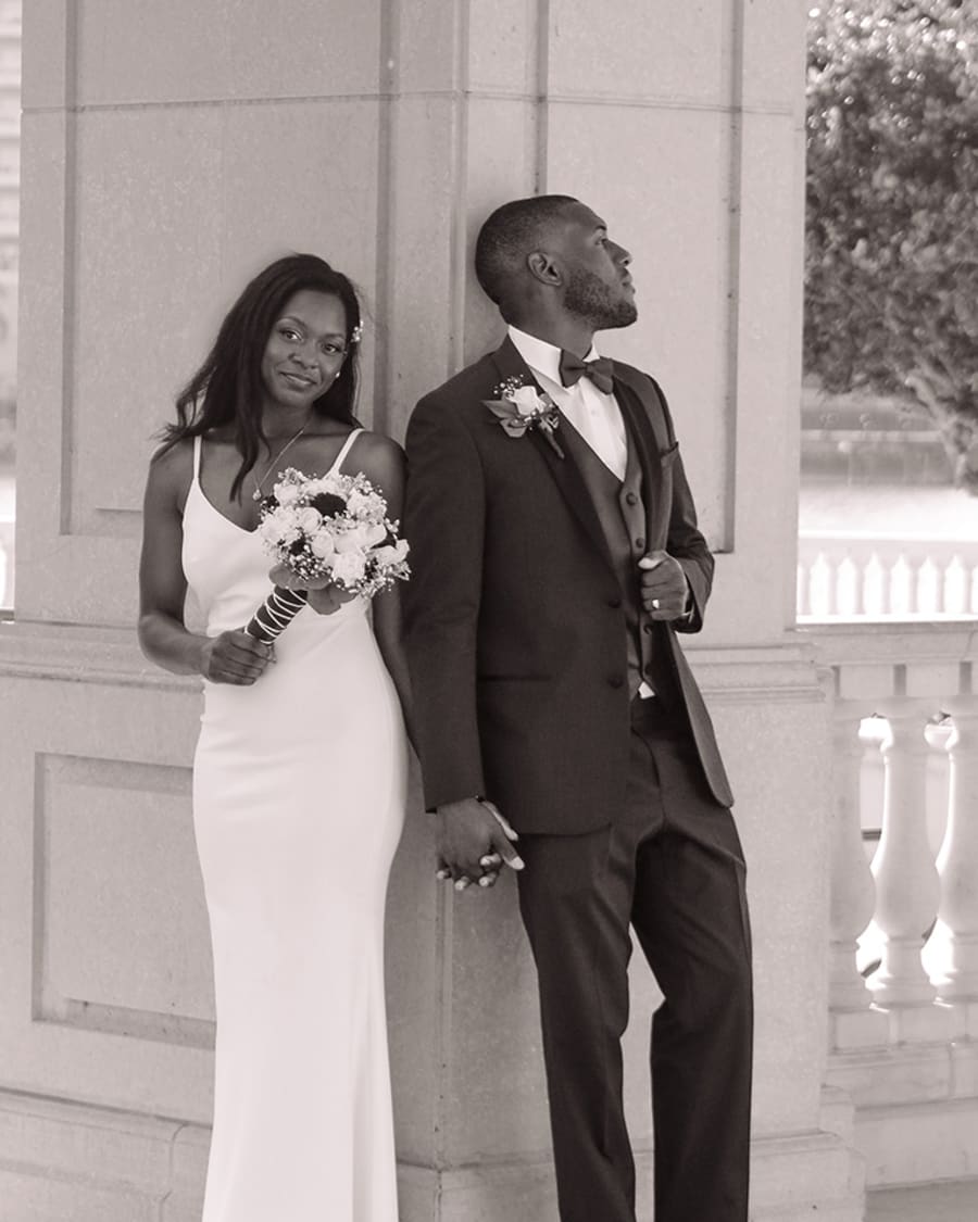 A married couple leaning against a pillar