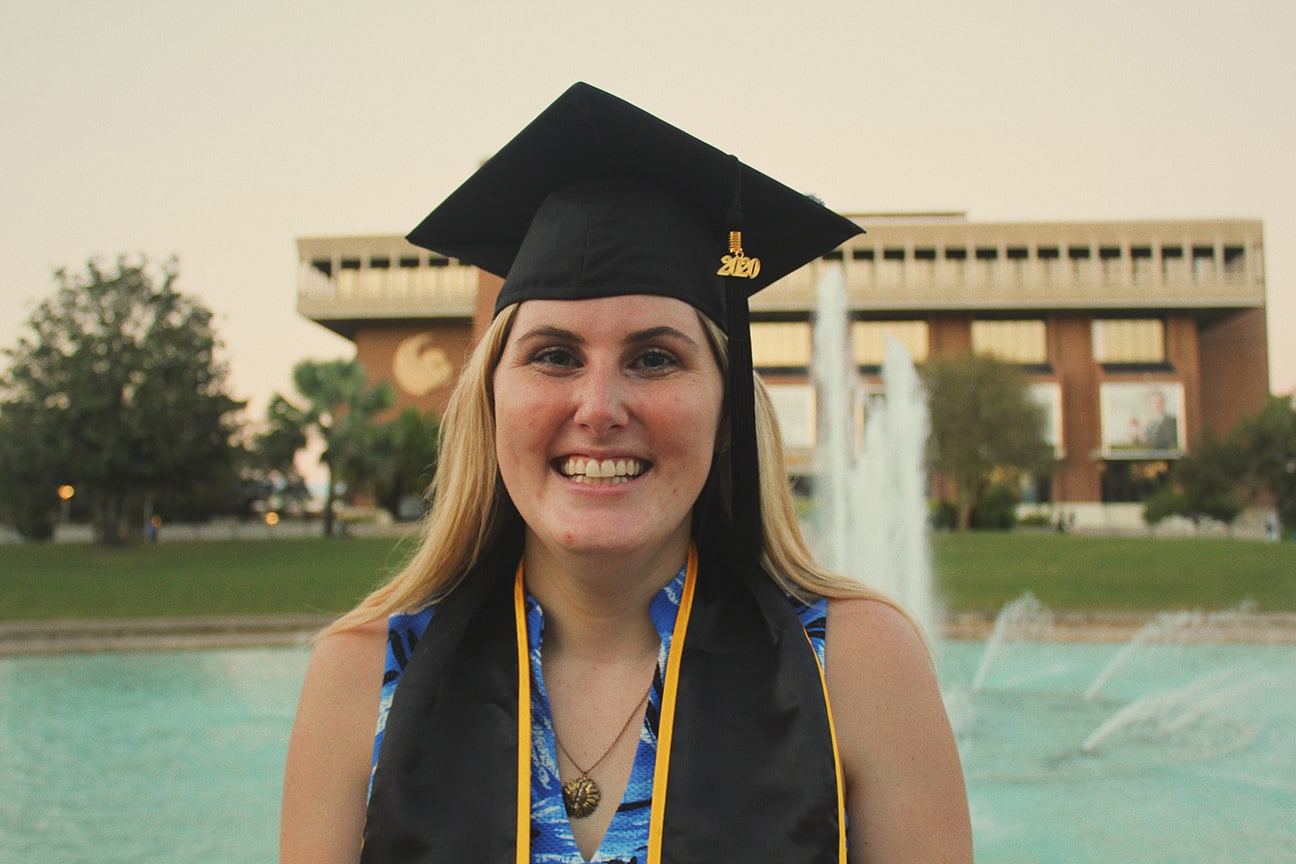 Girl graduating from UCF with fountain and library w1wemy