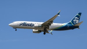 Passenger attempts to open Alaska Airlines cabin door, restrained by crew.
