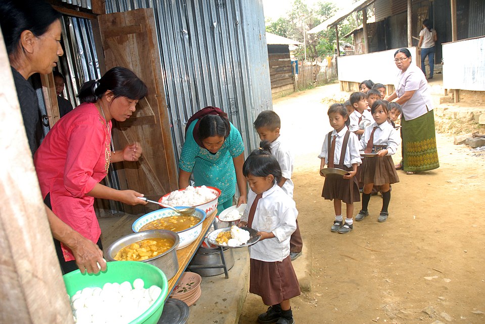 Schoolchildren being served food under India's Mid-Day Meal Scheme, aimed at improving nutrition and school enrolment