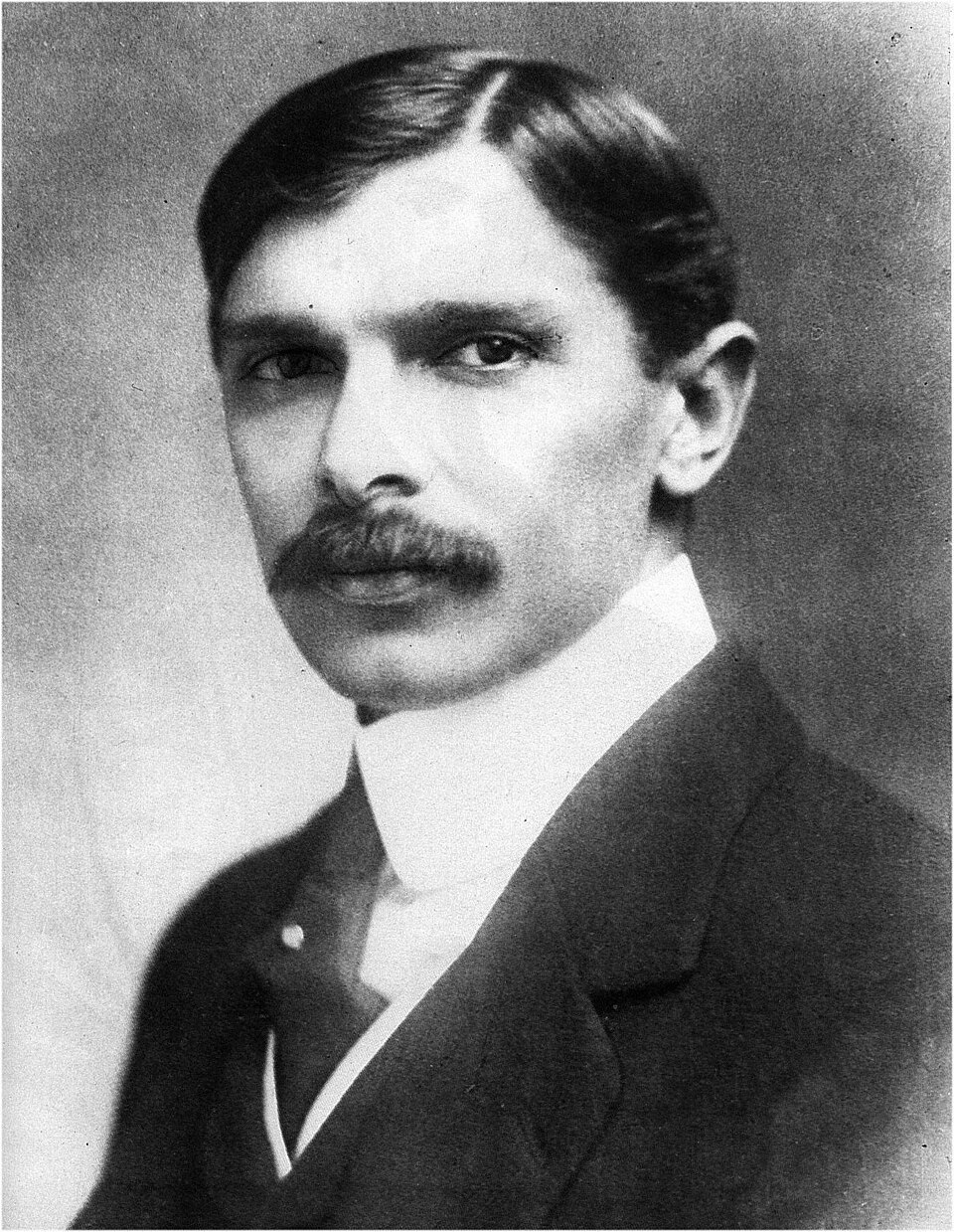 Black-and-white studio portrait of Muhammad Ali Jinnah in a dark suit and wing collar