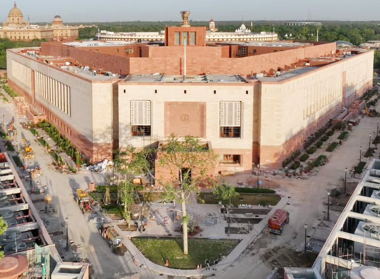 Aerial view of the triangular sandstone new Parliament Building (Sansad Bhavan) in New Delhi, with the national emblem mounted on its central roof