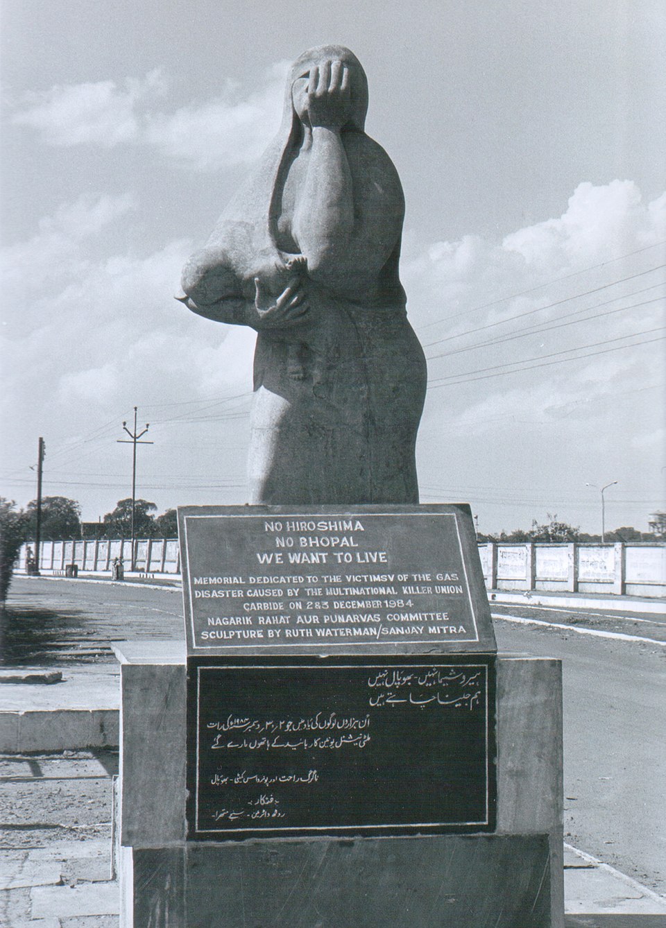 The Bhopal gas tragedy memorial statue of a grieving mother shielding a child, on a plinth reading No Hiroshima No Bhopal We Want To Live