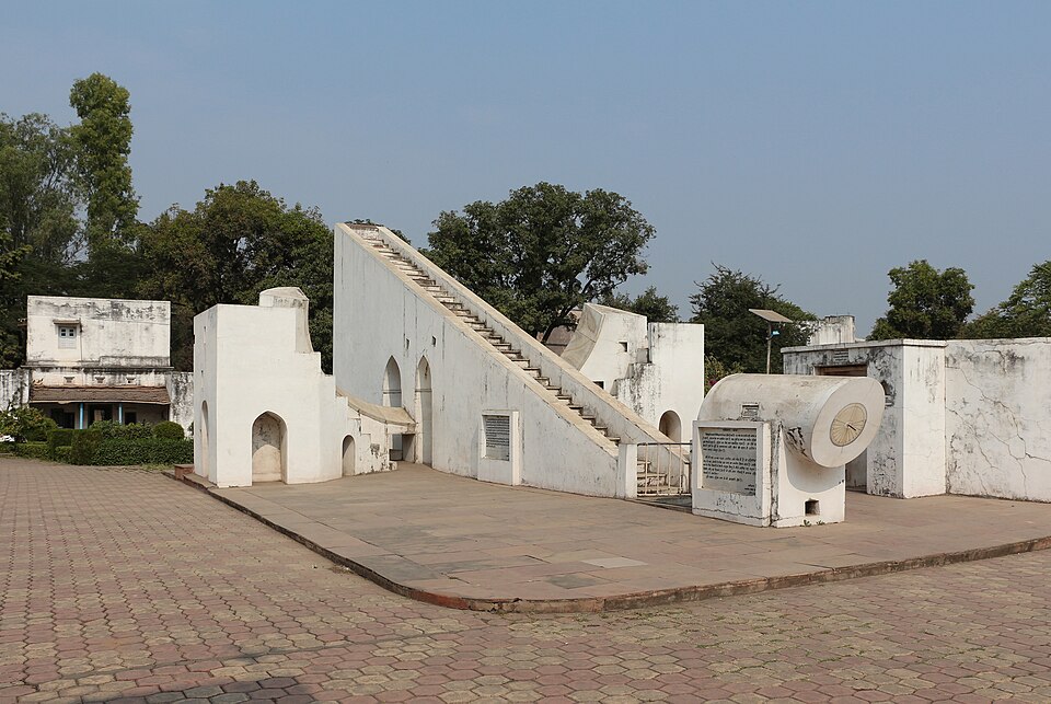 The whitewashed masonry instruments of the Vedh Shala at Ujjain, including the triangular Samrat Yantra sundial with its stepped gnomon and a circular dial