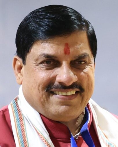 Portrait of Dr. Mohan Yadav, Chief Minister of Madhya Pradesh, smiling, in a maroon kurta with a tilak on his forehead and a shawl round his shoulders