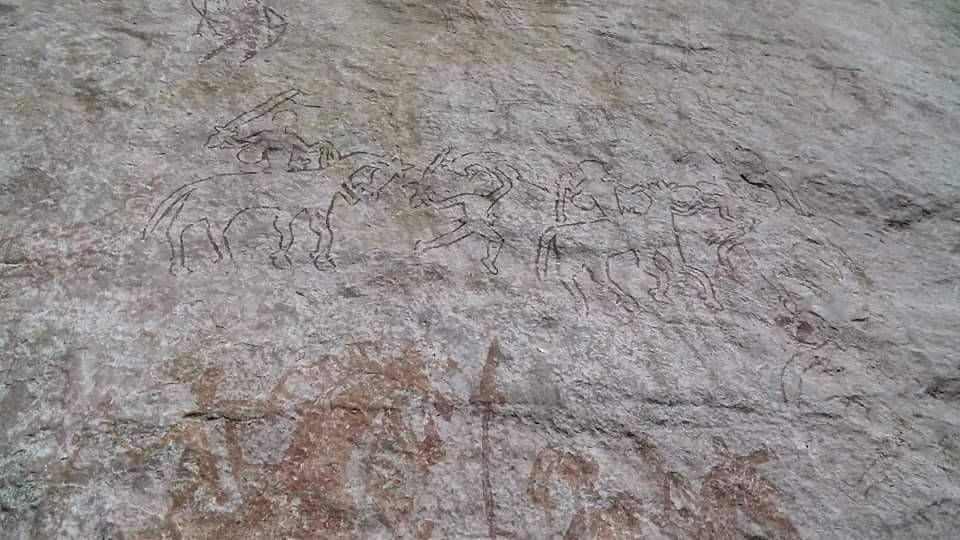 Prehistoric rock art at Adamgarh: line drawings of animals and mounted figures incised on a pale rock-shelter wall