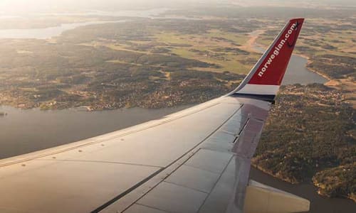 Person søker etter billige flybilletter og restplasser på laptop i 2025