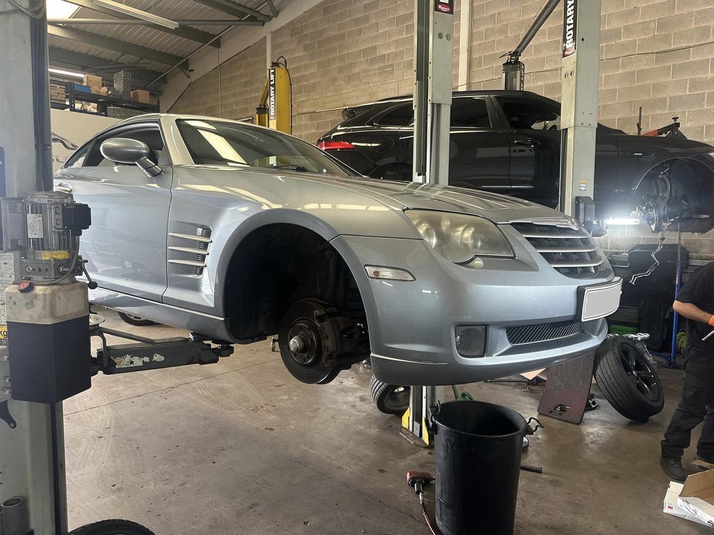 Chrysler Crossfire on a lift with its wheels off during a service at Mitsiland