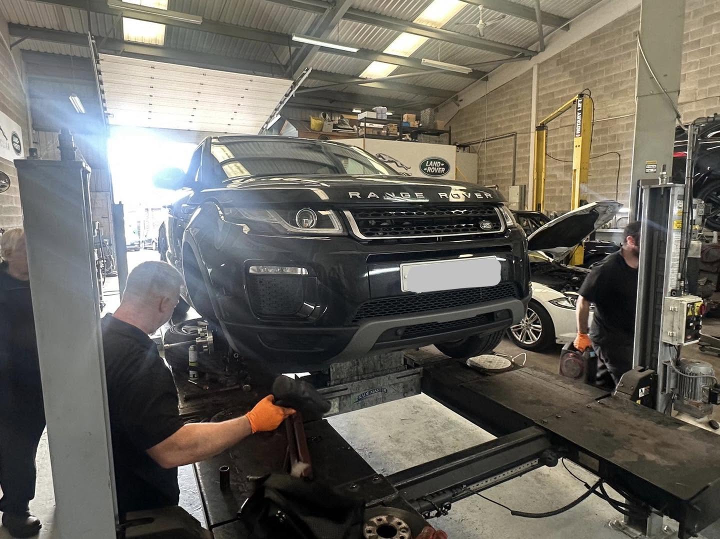 Range Rover Evoque on the MOT lift while a technician inspects underneath