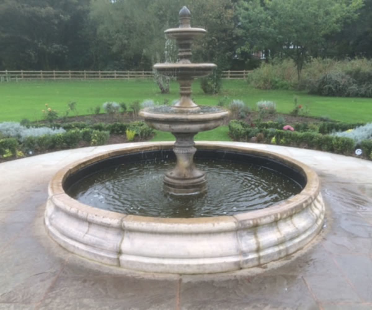 Three tiered Edwardian fountain in a large Chester pool surround acting as a garden focal point