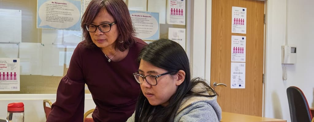 Children sitting criss-cross applesauce in the classroom.