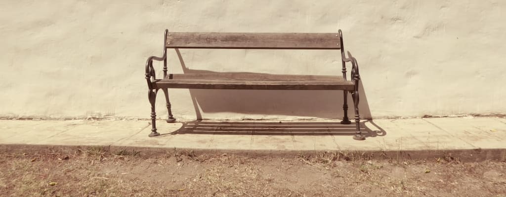 The jockey sat on the baseball bench.