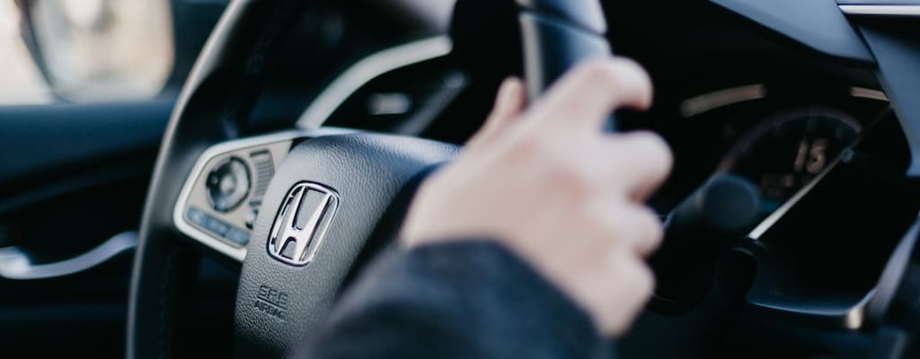 Driving a vintage car with a manual transmission and gear shift.