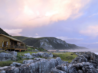 Trähus på klippor med utsikt över havet vid Plettenberg Bay, Sydafrika