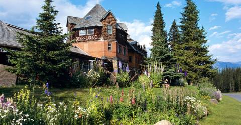 Hus och blommande trädgård på Deer Lodge vid Lake Louise i Banff National Park, Kanada