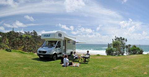 Parkerad husbil från Maui med picknick på gräsmatta vid kusten, Nya Zeeland
