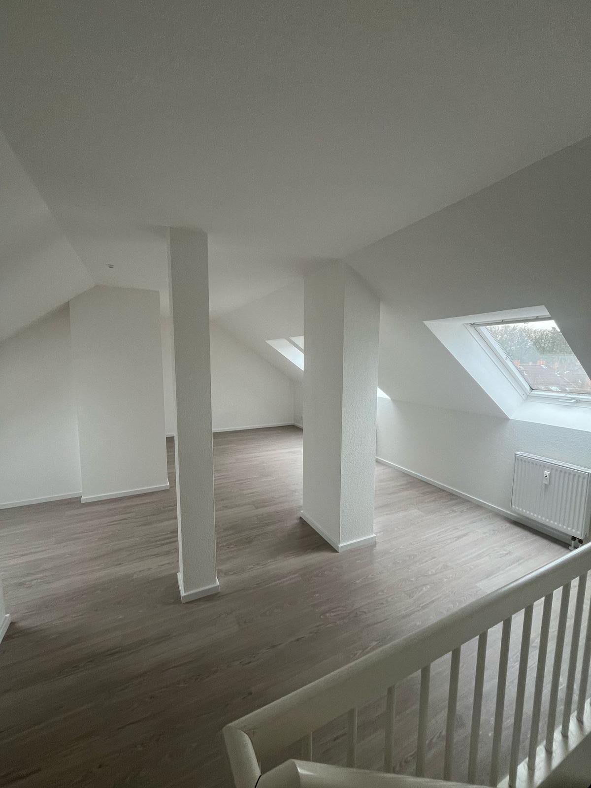 Ausgebautes Dachgeschoss in Frankfurt mit Dachfenstern, verkleideten Stützen und neuem Bodenbelag