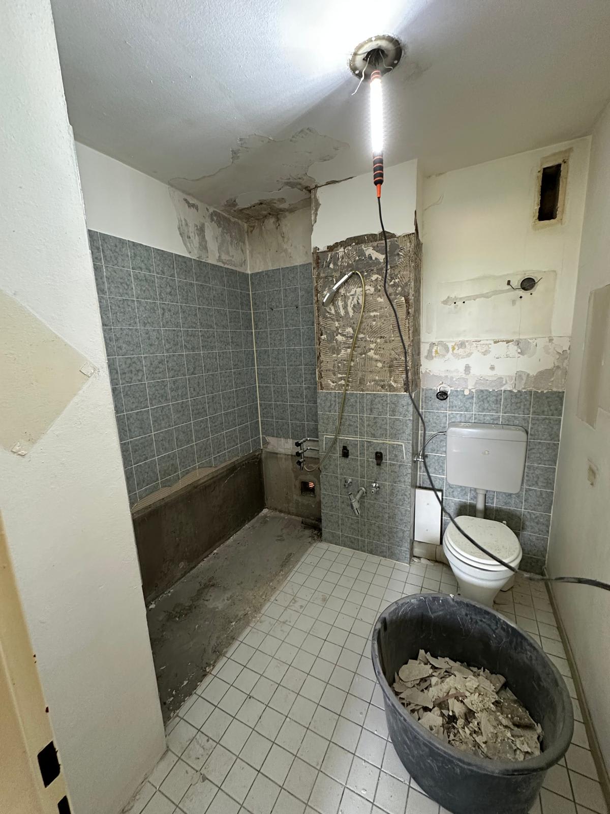 Bad in Frankfurt-Berkersheim vor der Sanierung – Wasserschaden, alte Fliesen und ausgebaute Badewanne