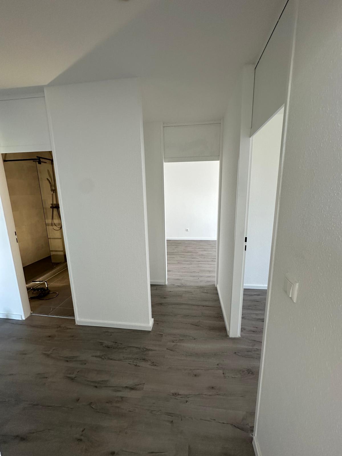 Flur nach der Kernsanierung in Frankfurt-Berkersheim mit neuem Designbelag in Holzoptik und neuer Raumaufteilung