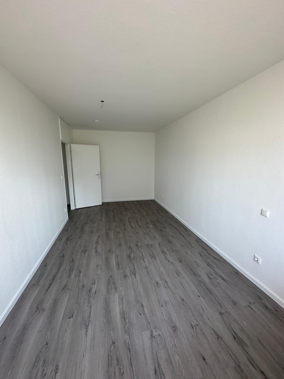 Zimmer nach der Kernsanierung in Frankfurt-Berkersheim mit neuem Designbelag und glatt gespachtelten Wänden