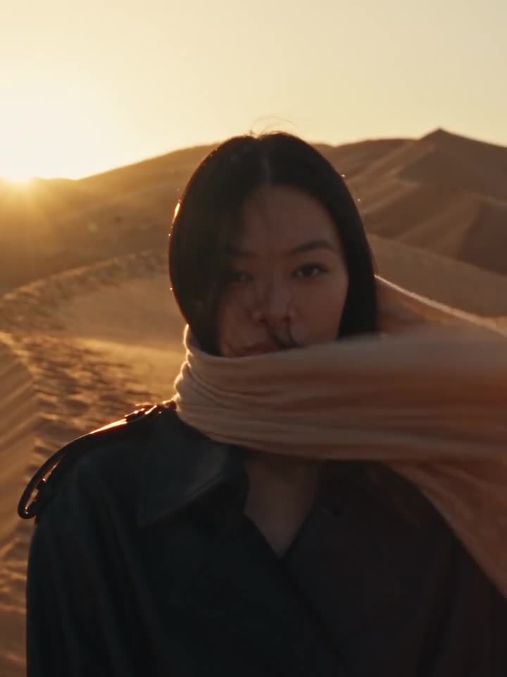Alexandra Lim, with a scarf blowing across the dunes at golden hour