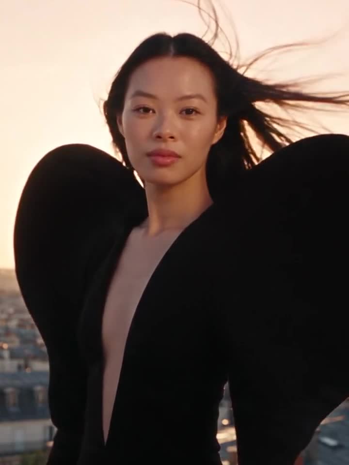 Alexandra Lim, in a sculptural black gown on a Paris rooftop at sunset