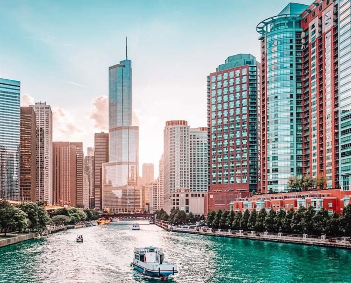 Bright view of the Chicago Riverwalk with very blue water and a clear blue sky