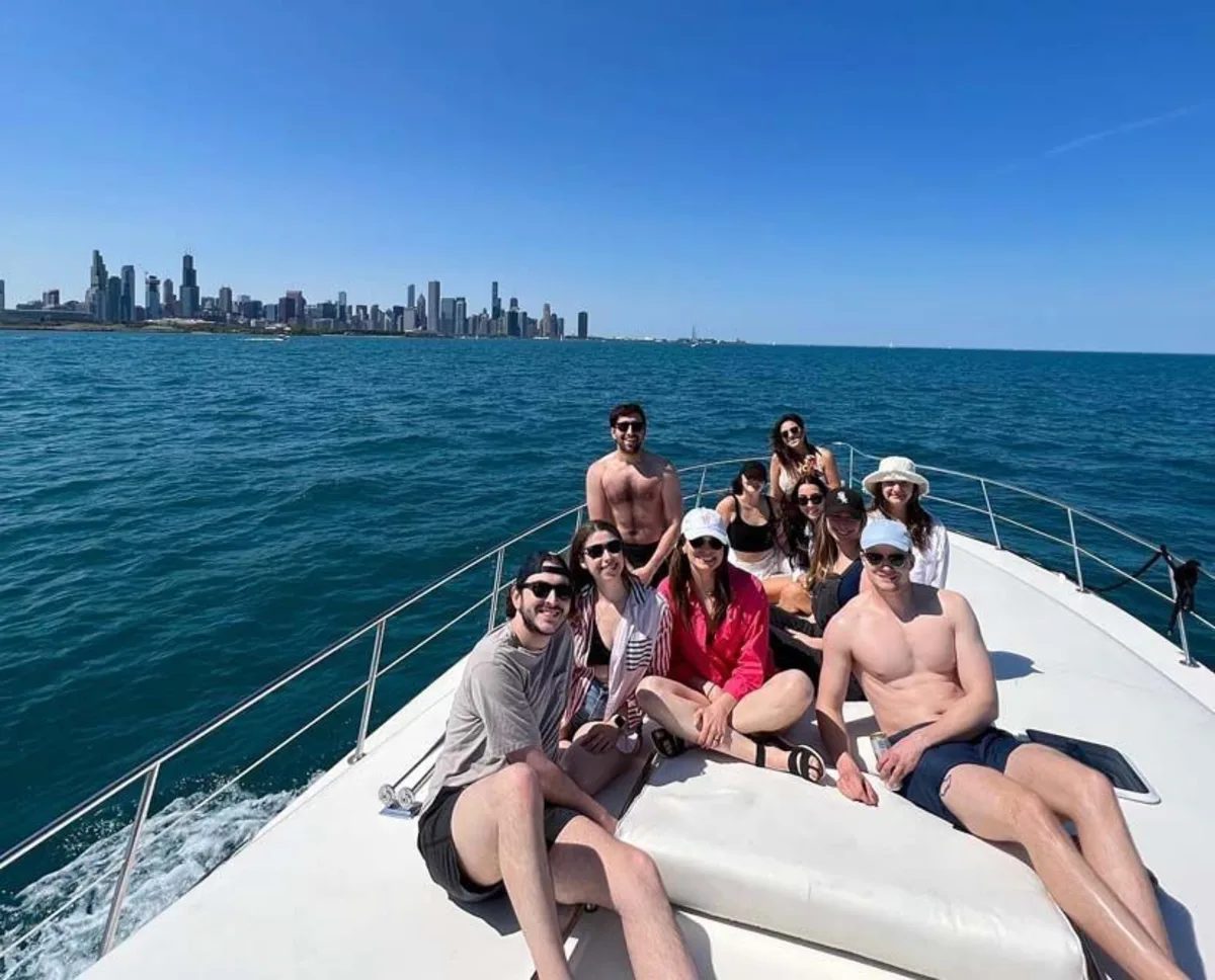 Group of friends sitting on the bow of a boat with a view of the Chicago skyline