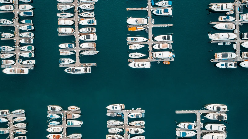 Aerial view of a harbor with rows of docked boats