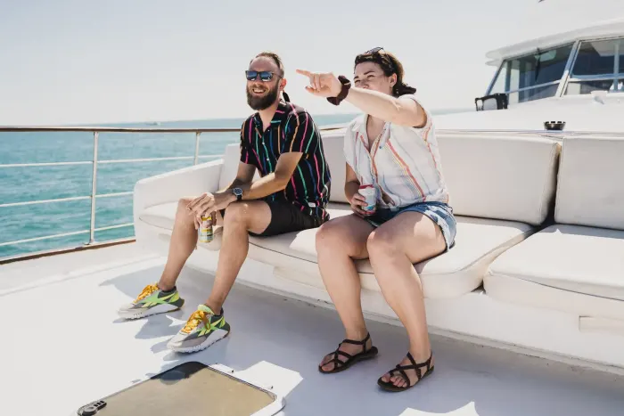 two men sitting on the bow of a boat pointing at the Chicago skyline